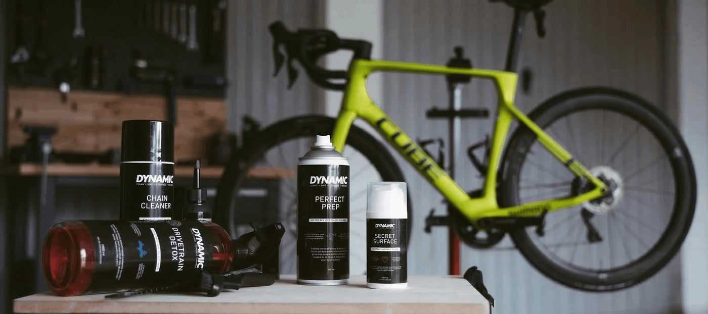 Bicycle cleaning products on a stand with a bicycle in the background